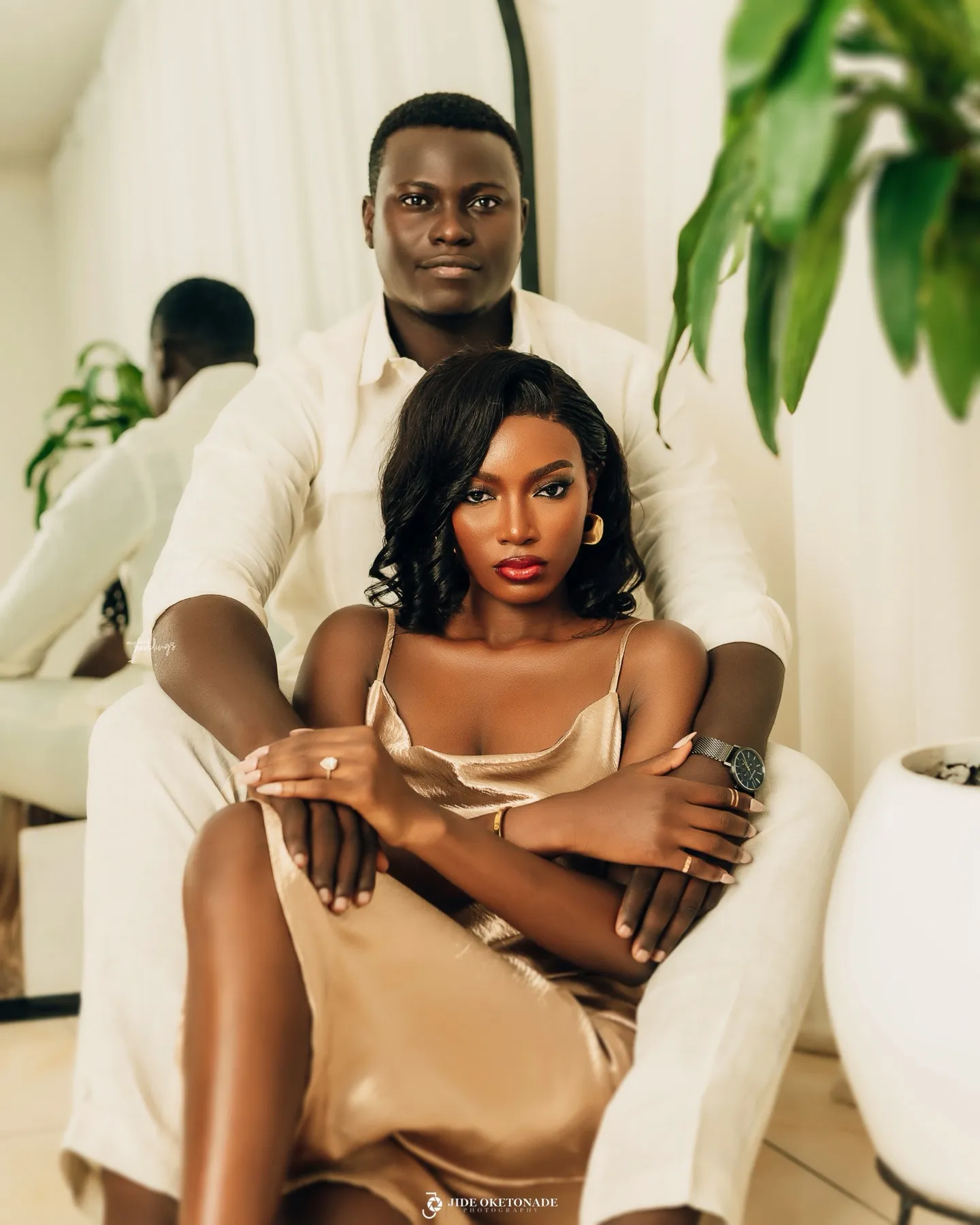Esther in champagne satin seated in front of Deji