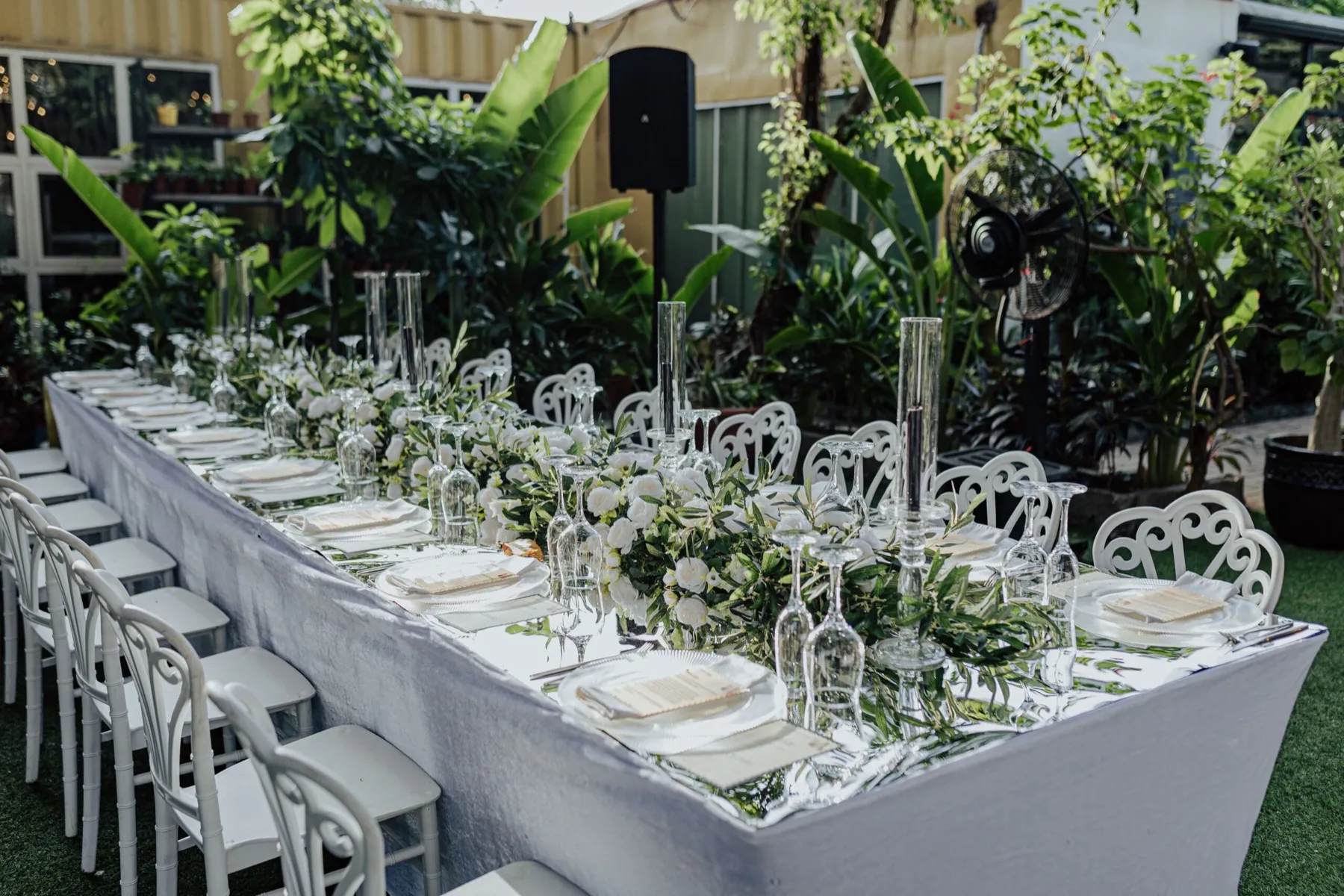 White chairs along a dressed garden table