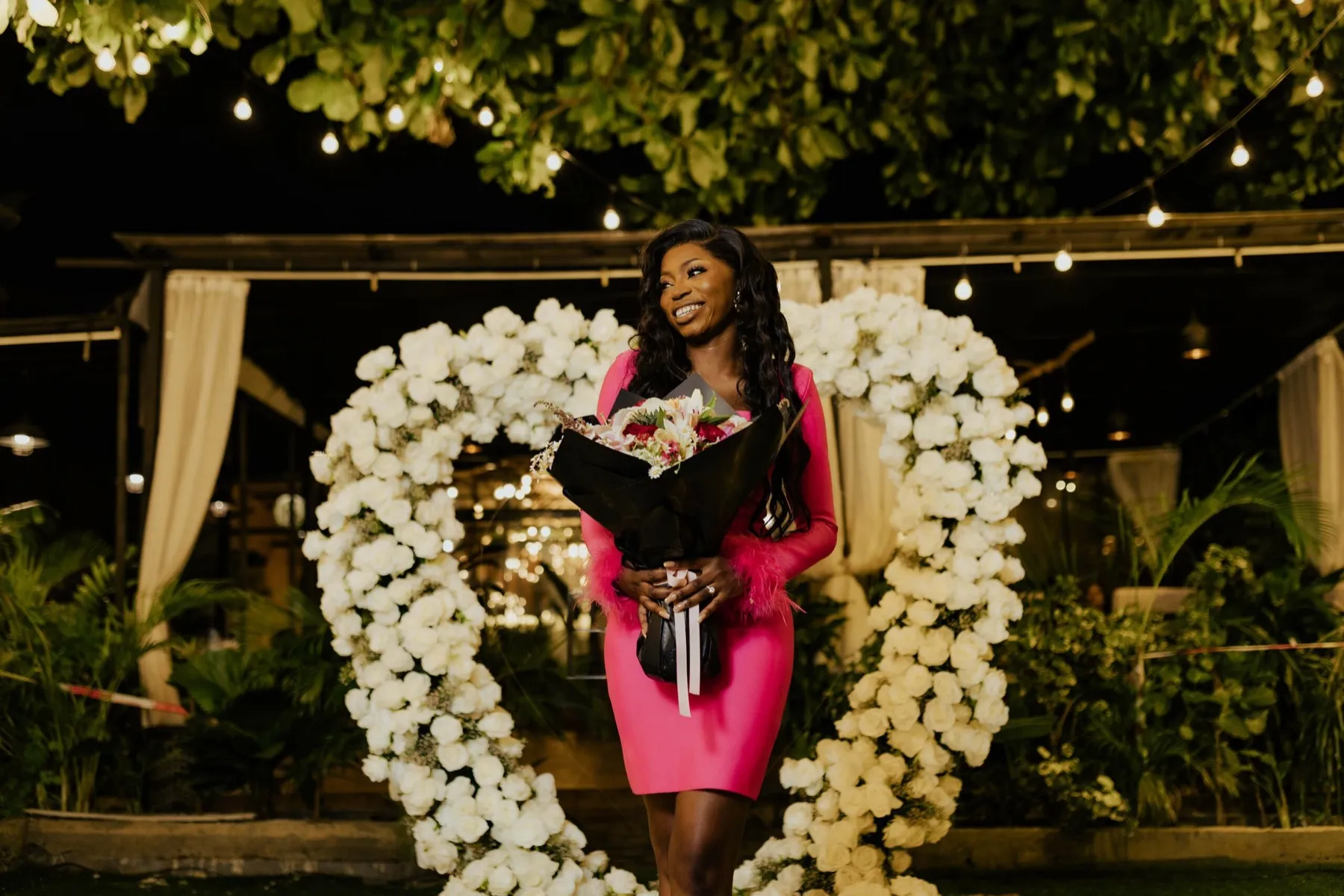 Habibat in pink holding her bouquet by the heart