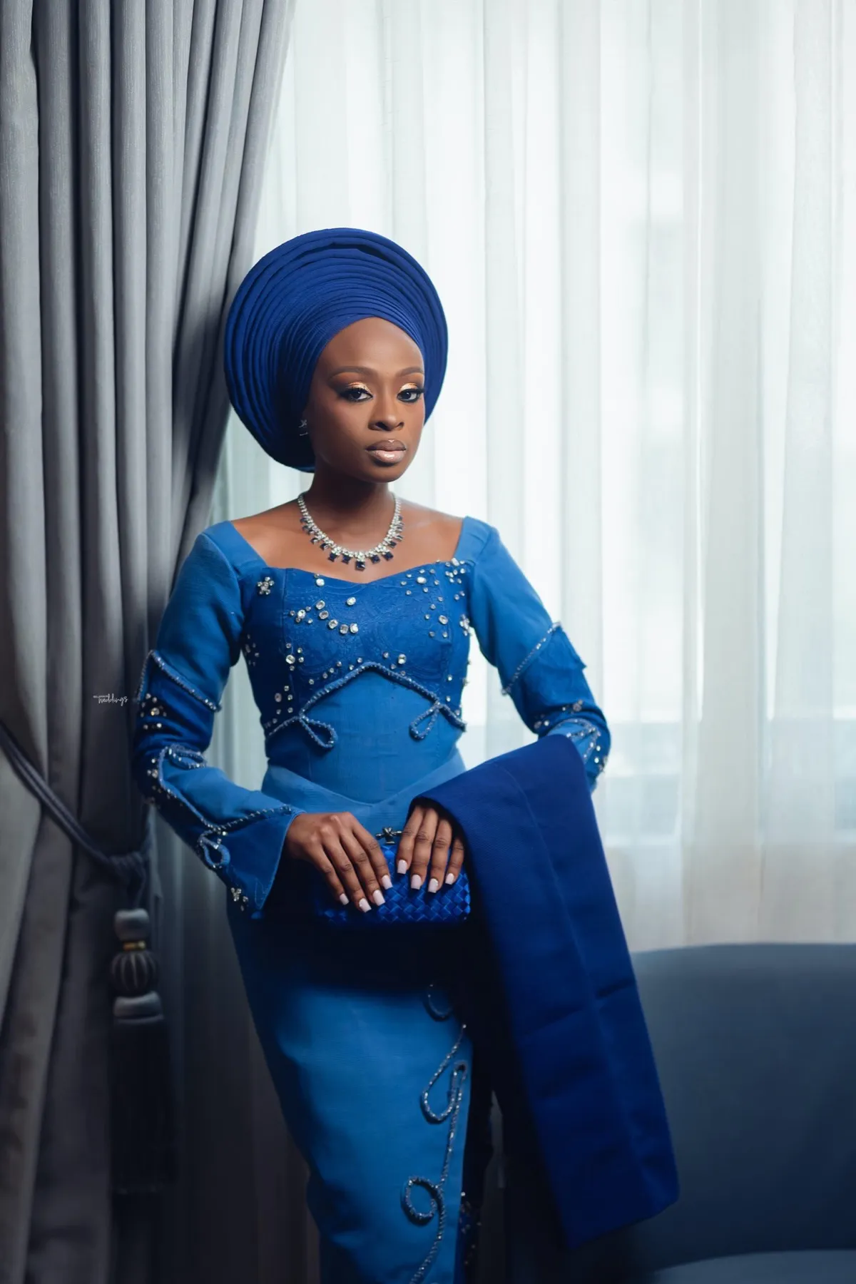 Lade in a blue beaded gown and gele