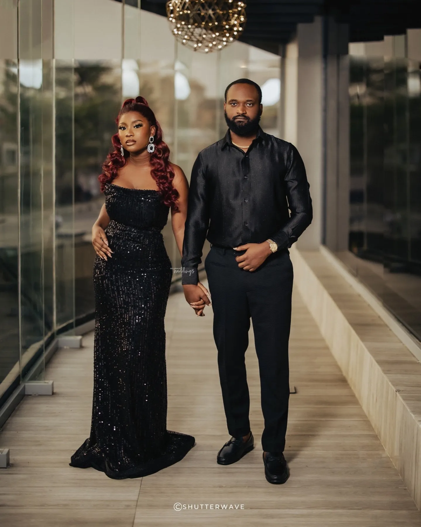 The couple standing together in black on a terrace