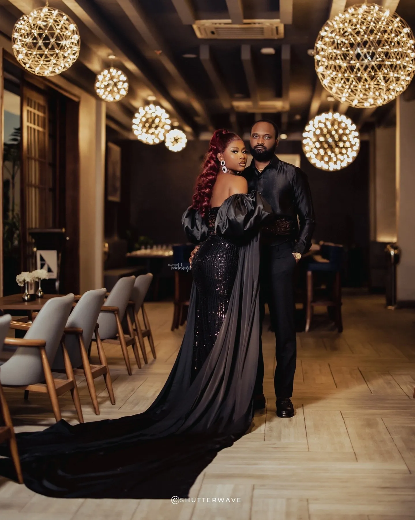 Zoe in a black gown with a long train in a restaurant